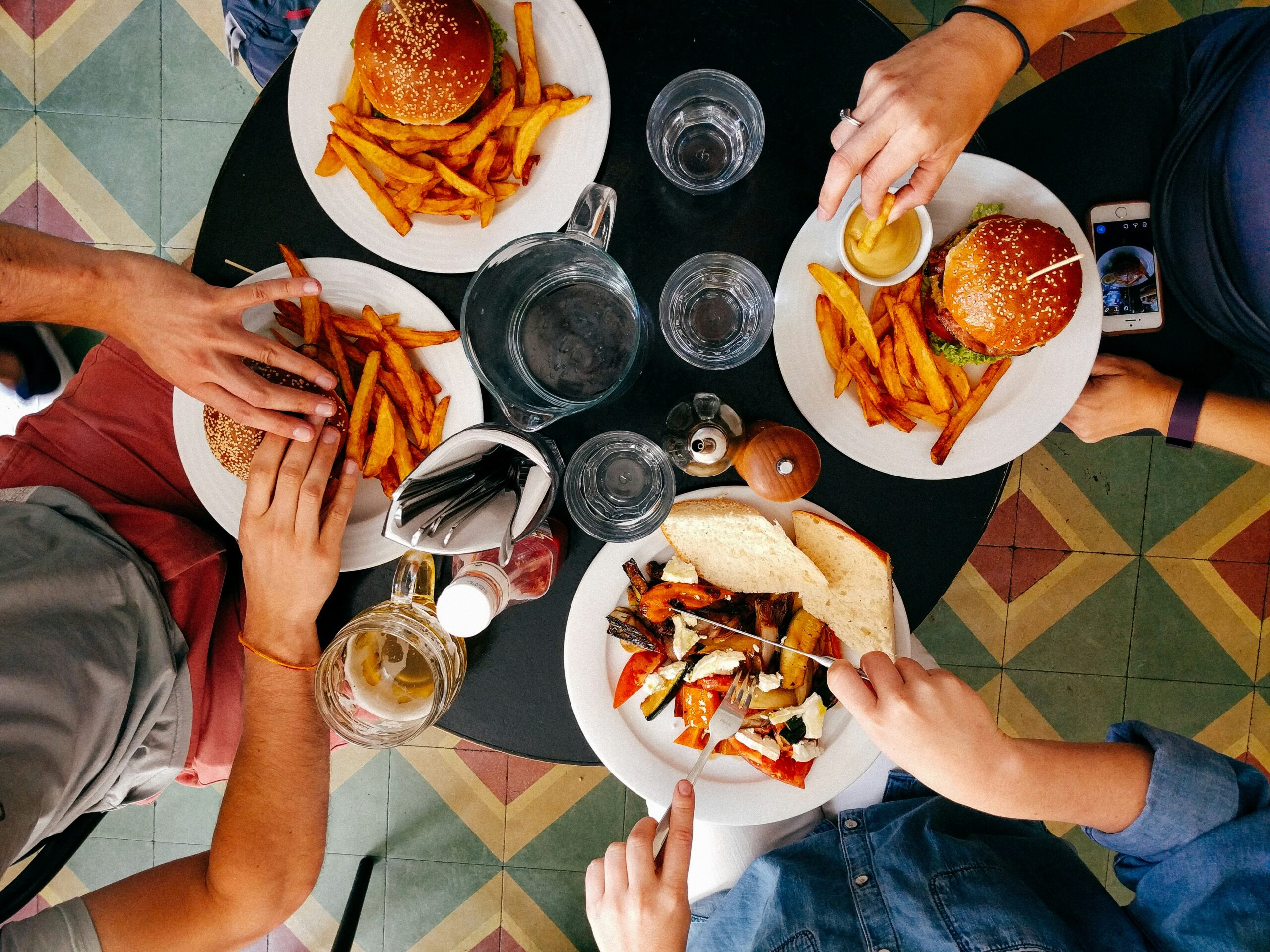 four people eating burgers from above